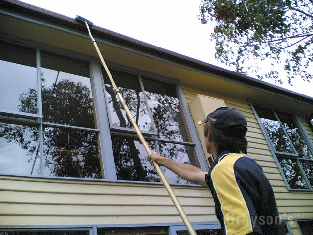 Washing a double storey gutter and fascia with an extension pole. 