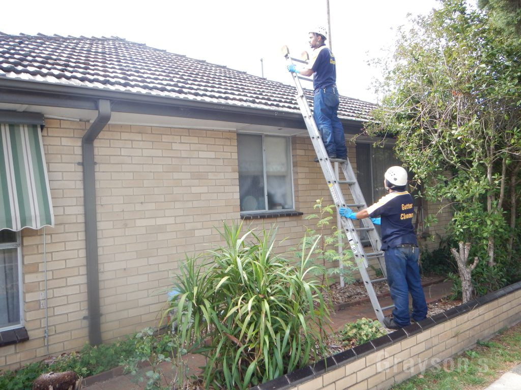 gutter cleaning on a an old roof with broken tiles