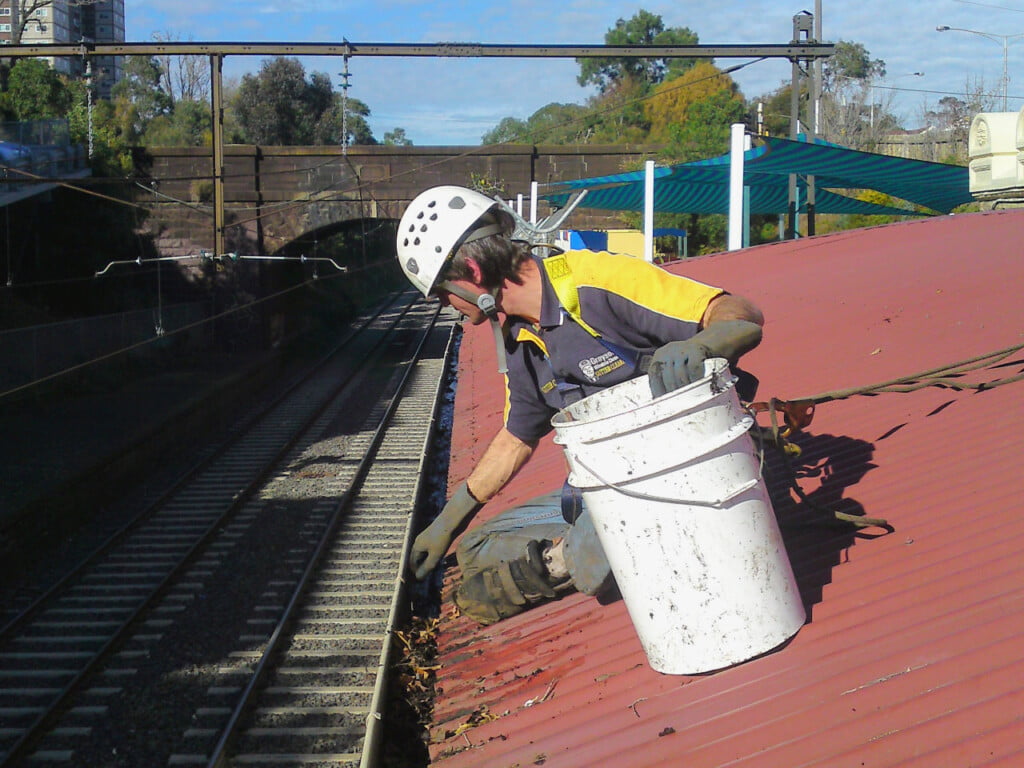 Cleaning the gutter on a train station